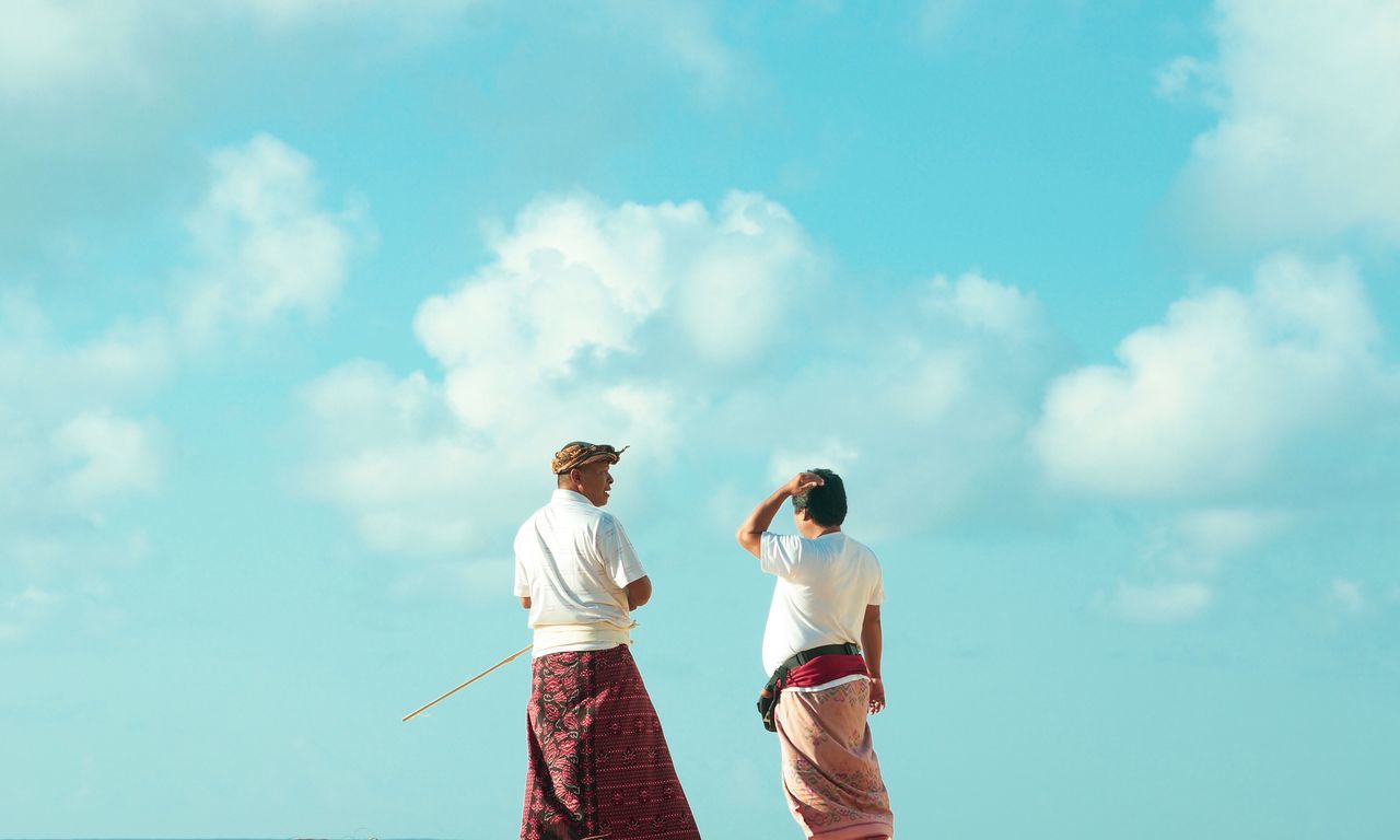 sky, cloud - sky, standing, togetherness, lifestyles, day, nature, real people, three quarter length, two people, leisure activity, men, clothing, casual clothing, adult, women, bonding, rear view, sunlight, love, outdoors, couple - relationship, positive emotion, care