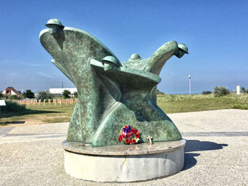 Statue of people in park against clear sky