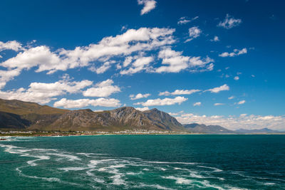 Scenic view of sea and mountains against blue sky