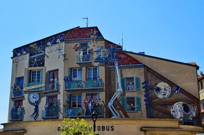 People outside house against clear blue sky