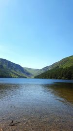 Scenic view of lake against clear blue sky