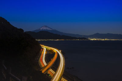 Light trails on road against sky at night