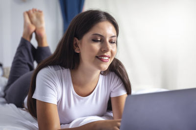 Young woman using mobile phone at home