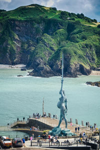 Statue of verity against harbour and surrounding landscape.