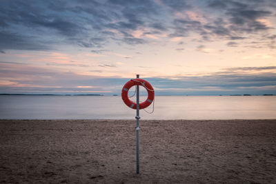 Lifeguard hut on beach against sky during sunset