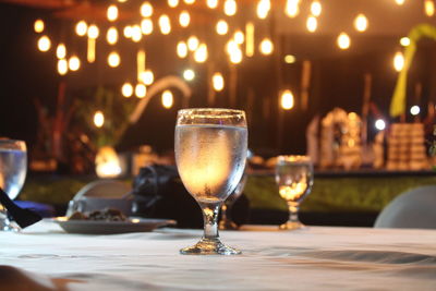 Close-up of wine glass on table at illuminated restaurant