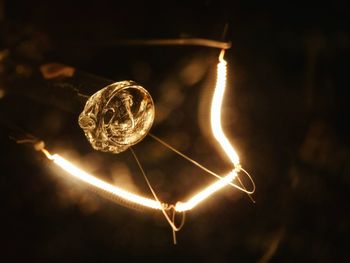 Close-up of illuminated lighting equipment against black background