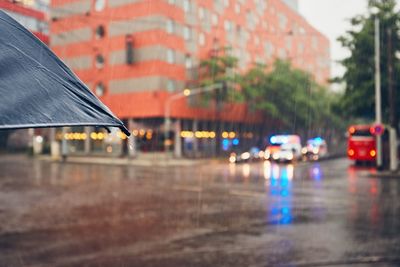 Cropped image of umbrella on street during rainy season