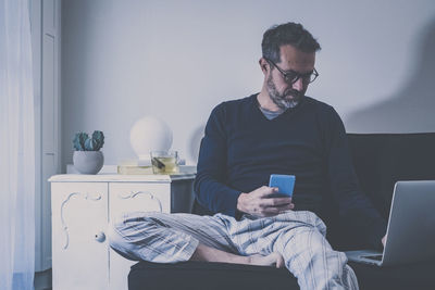 Man works with laptop on sofa. boy shopping online with computer. technology people  at home concept