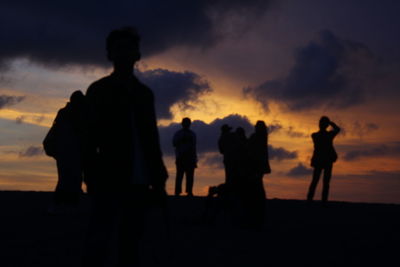 Silhouette people standing against sky during sunset