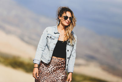 Young woman standing against mountain