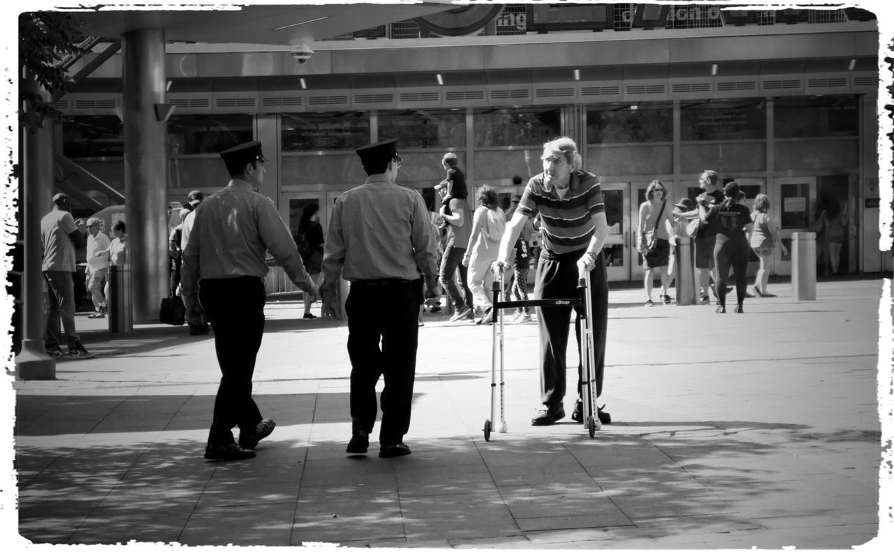 REAR VIEW OF PEOPLE WALKING ON FOOTPATH