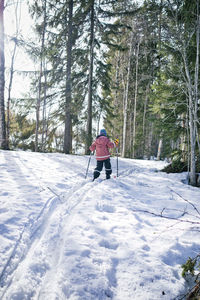 Rear view of woman walking on snow covered land