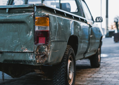 Close-up of wet motorcycle on street in city