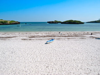 Scenic view of beach against clear blue sky