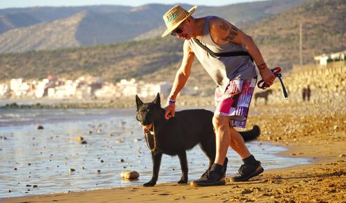 Full length of man with dog on shore