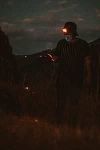 Man standing on field at night