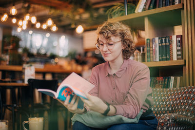 Portrait of smiling young woman sitting in store