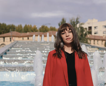 Portrait of beautiful woman standing against fountains outdoors