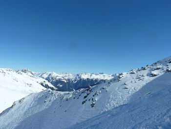 Scenic view of snowcapped mountains against clear blue sky