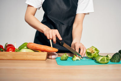 Midsection of female chef cutting food on table