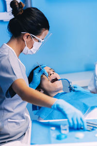 Female dentists examining woman at clinic