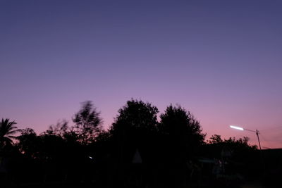 Low angle view of silhouette trees against sky at night