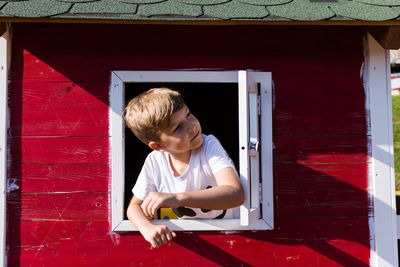 Smiling boy in window of house