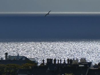High angle view of airplane flying over sea against sky