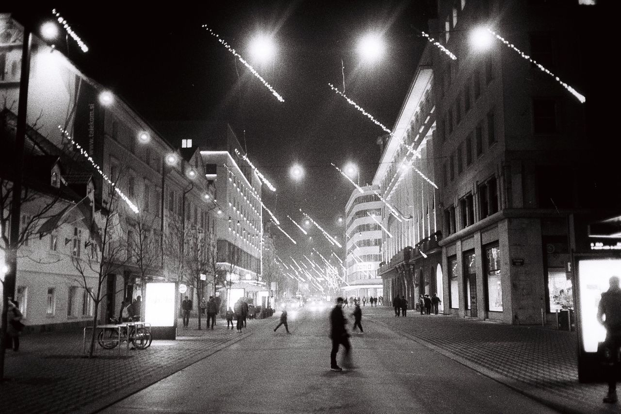 MAN ON ILLUMINATED STREET AT NIGHT