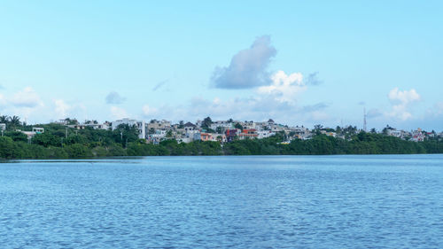 Scenic view of sea by buildings against sky