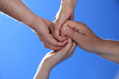 Close-up of cropped hand against clear blue sky