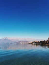 Scenic view of lake against clear blue sky