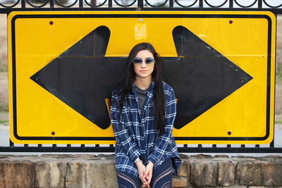 Full length of woman standing against yellow wall