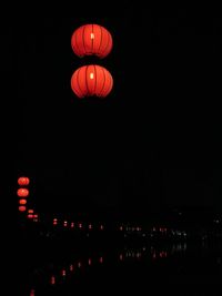 Low angle view of illuminated lanterns against clear sky at night