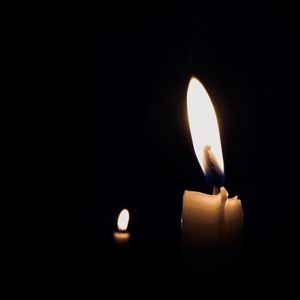 Close-up of lit candle in darkroom