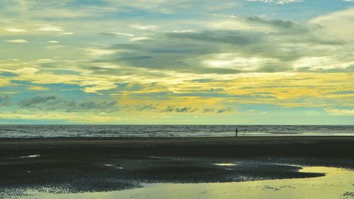 Scenic view of beach against sky during sunset