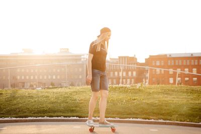 Full length of woman standing against sky in city