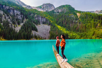 Rear view of woman standing by lake