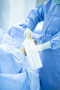 Midsection of doctor performing surgery