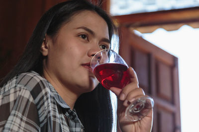 Portrait of young woman drinking glass