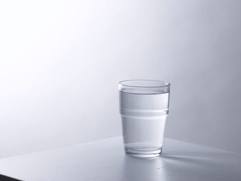 Glass of clear water on the gray background