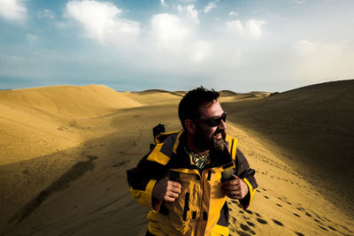 Man standing at desert against sky