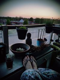 Midsection of woman sitting at table against sky