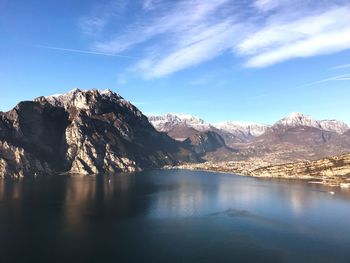 Scenic view of lake by mountains against sky
