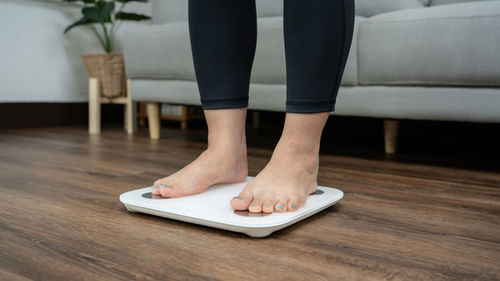 Low section of woman using laptop on table