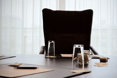 Close-up of office desk by empty chair