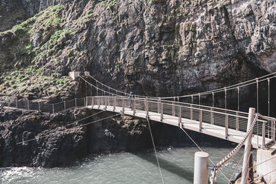 Bridge over rocks against sky