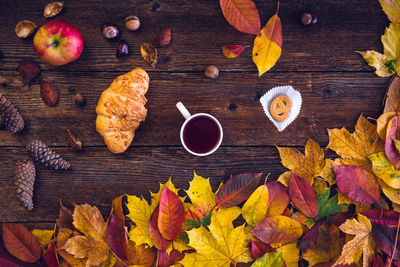 Directly above shot of autumn leaves with food on table