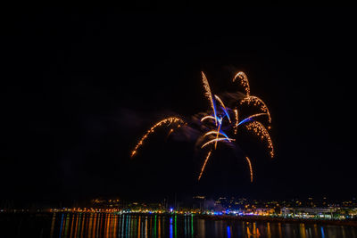 Firework display over river at night